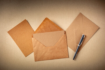 Greeting card mockup in a brown kraft envelope, with a blank card, shot from the top on brown paper