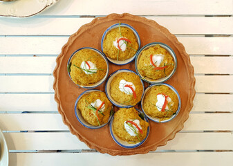 Thai streamed red curry in the small cup serving on terracotta plate