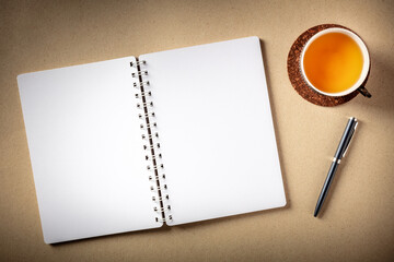 Open journal and a cup of tea, a flat lay overhead shot on a rustic background