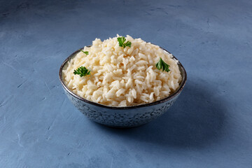 White rice, cooked, served with parsley, on a blue background