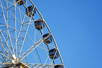 Fragment of the Ferris wheel structure on a blue sky background close-up