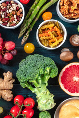 Vegan food. Fruit and vegetables, legumes, nuts, mushrooms, pasta, organic products, shot from above on a dark background