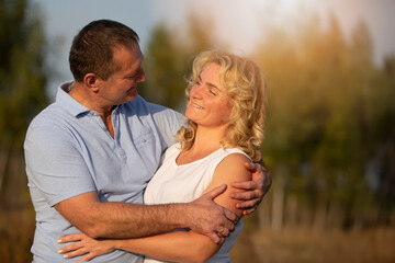 Obraz premium A beautiful middle-aged couple in love hug and look at each other.