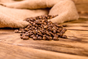 Sackcloth and scattered coffee beans on wooden table