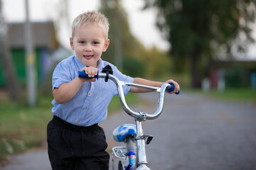 Fototapeta na wymiar Happy little boy rides a red toy motorcycle.