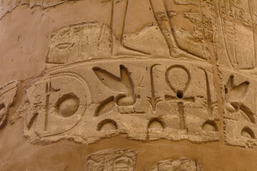 Egyptian ancient hieroglyphs on the stone wall. Closeup of the symbol of eternal life ankh