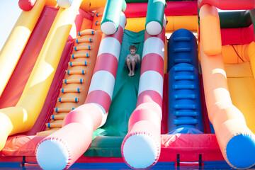 The boy slides down the inflatable slide.