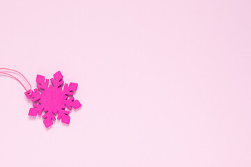 Fototapeta na wymiar Pink snowflake on a light pink background.