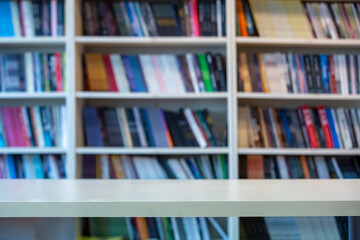 wooden table standing in front of bookshelf background.
