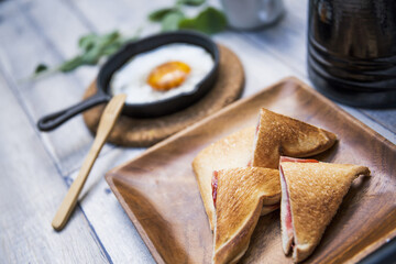 目玉焼きと苺ジャムのホットサンドのアウトドアな朝ごはんのイメージ