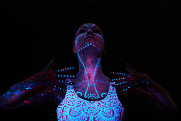 Art woman cosmos in ultraviolet light. Entire body is covered with colored droplets. Girl posing in the dark. Noise, out of focus