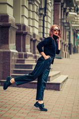 Beautiful girl of model appearance posing on a street of a European city