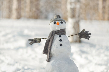 happy child girl plaing with a snowman on a snowy winter walk