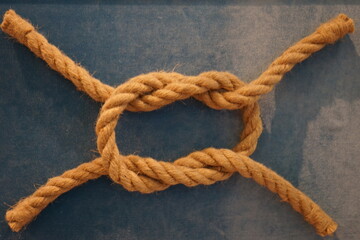Fototapeta na wymiar symbol of a sea knot made of rope on a blue background