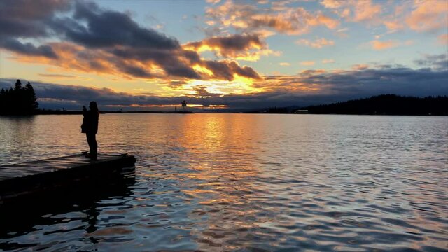 Woman taking photos of sunset on Lake Superior