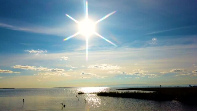 HD MOTIONLAPSE pan left to right from sun and reflection on waterway to Atlantic City skyline in distance with partly cloudy sky, also available in 4K