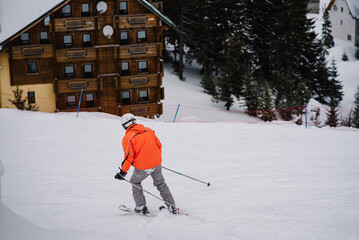 Man on skis descend down from the mountain on snow track on background of forest. Skiing. Extreme...