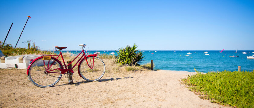 Vieux vélo rouge e, bord de mer sur les plages de France.