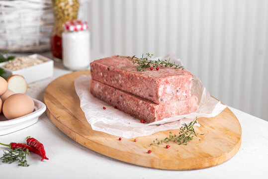 Semi-finished meat, seasoned on a wooden background.