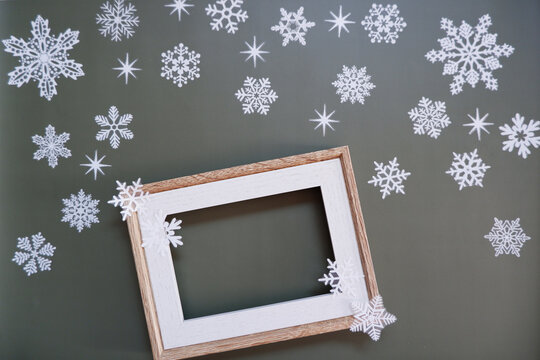 A empty photo frame with snowflakes decoration. Winter greeting. 雪片と写真立て、冬のイメージ