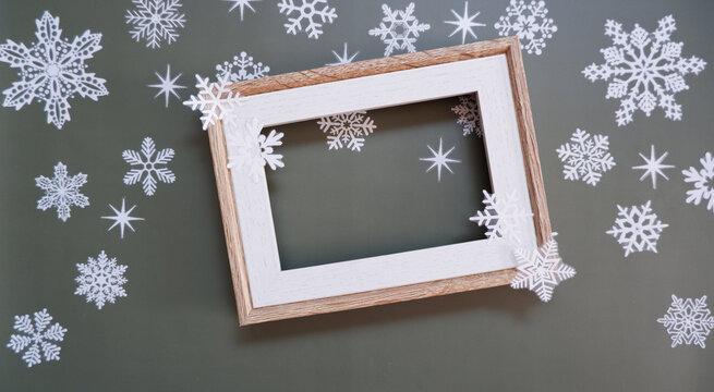 A empty photo frame with snowflakes on gray background. Winter greeting. 雪景色とフレーム、スノーフレーク