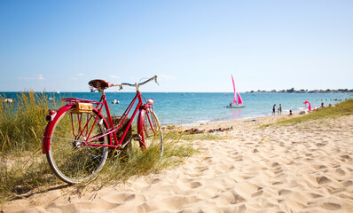 Vieux vélo rouge en bord de plage sur le littoral français. - obrazy, fototapety, plakaty