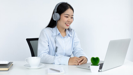 Young white Asian woman studying via the internet in her home office.