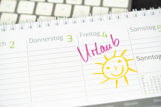 The entry of the German word for vacation and the drawing of a smiling sun in a desk calendar