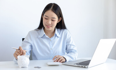 Businessman's hand holds the money in the piggy bank for saving money for future use, saving money for finance accounting concept.