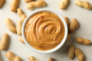 Bowl with peanut butter and peanut on white background