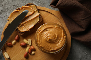 Concept of tasty breakfast with peanut and peanut butter on gray table