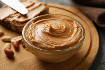 Concept of tasty breakfast with peanut and peanut butter on gray table