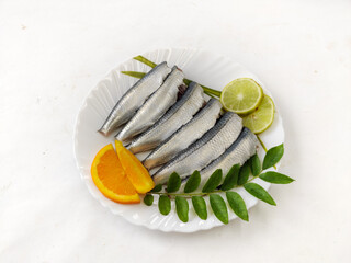 Cleaned and ready to cook fresh indian sardine decorated with curry leaves,lemon slice and tomato...