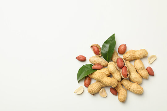 Pile of peanuts with leaves on white background