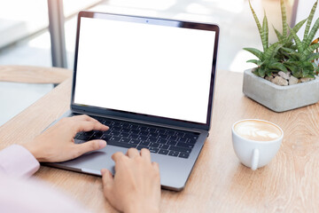 Fototapeta premium computer blank screen mockup.hand woman work using laptop with white background for advertising,contact business search information on desk at coffee shop.marketing and creative design