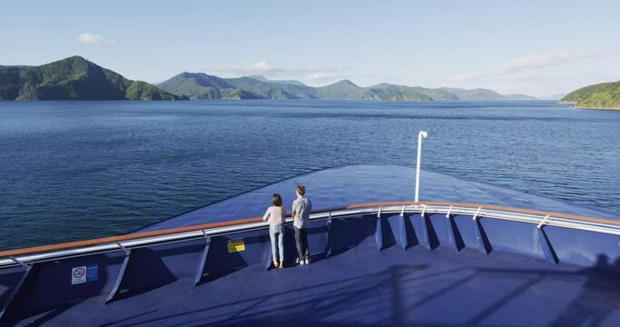 New Zealand cruise travel people enjoying nature view of ferry boat cruising in Marlborough sounds trip from Picton to Wellington, Cook strait crossing. Couple tourists watching sunset on deck.