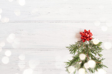 Fototapeta na wymiar Photo of Christmas tree with bokeh on the white wooden background