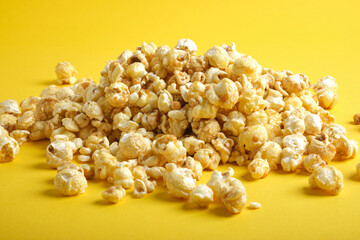 tasty caramel popcorn on a yellow background