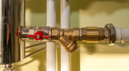 Tap and filter from the hydraulic arrow and polypropylene pipes close - up on the wall background