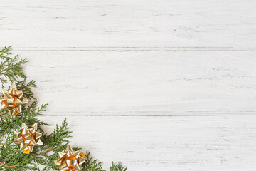 Flat lay of Christmas decorations on white wooden background. Christmas tree branches with golden gift ribbons and copy space