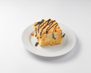 A piece of Napoleon cake with chocolate syrup served on a white plate over white background.