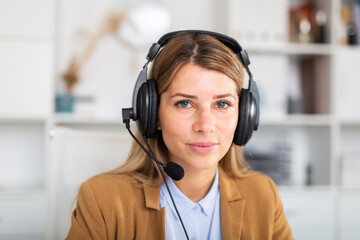 optimistic adult female operator sitting in white office