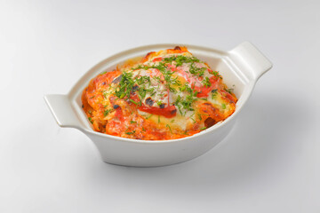 Italian lasagna served in a white pot over white background. Delicioud dinner concept, Italian cuisine.
