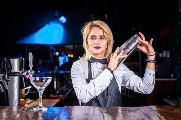 Girl bartender makes a cocktail on the public house