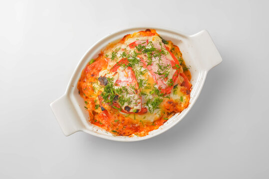 Italian lasagna served in a white pot over white background. Delicioud dinner concept, Italian cuisine.