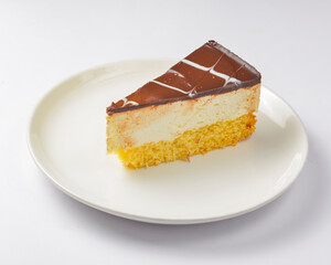 A piece of vanilla and chocolate cream cake on white background. Delicious sweet sugary dessert for tea time