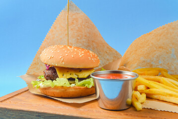 Hamburger with french fries and tomato dip sauce. Fast food, junk food concept.