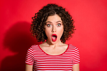 Photo of shocked surprised curly young lady wear casual striped outfit open mouth isolated red color background