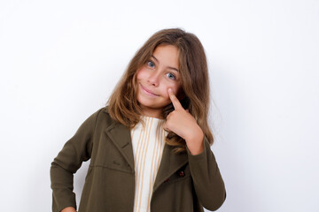 Beautiful little girl standing against white background, looking, observing, keeping an eye on an object in front, or watching out for something.