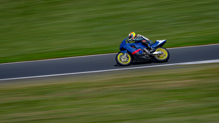 A panning shot of a racing bike cornering on a track.